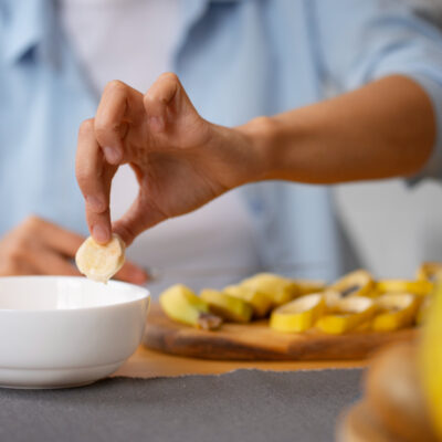 Persona comiendo pequeños bocados de fruta desde un plato