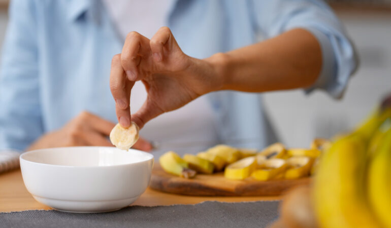 Persona comiendo pequeños bocados de fruta desde un plato